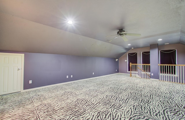 additional living space with ceiling fan, light colored carpet, and vaulted ceiling