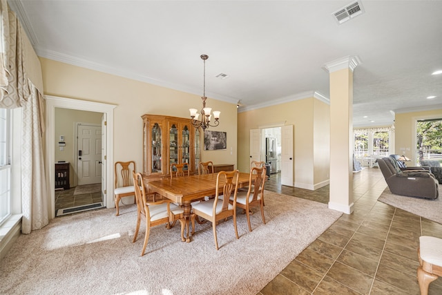 carpeted dining room featuring ornamental molding, ornate columns, and a notable chandelier