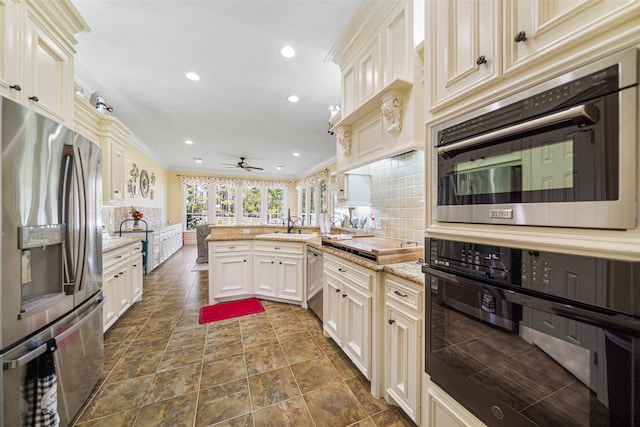 kitchen with backsplash, ceiling fan, ornamental molding, appliances with stainless steel finishes, and kitchen peninsula