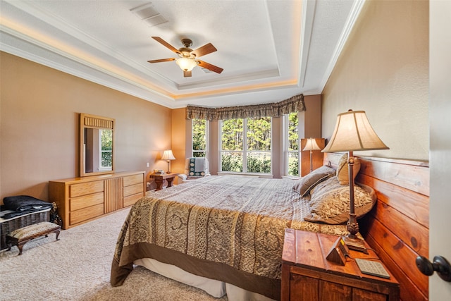 bedroom featuring carpet, a raised ceiling, ceiling fan, and ornamental molding