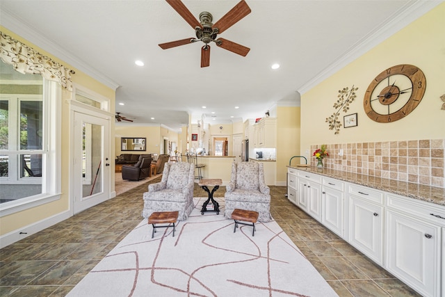 living room featuring ceiling fan and ornamental molding