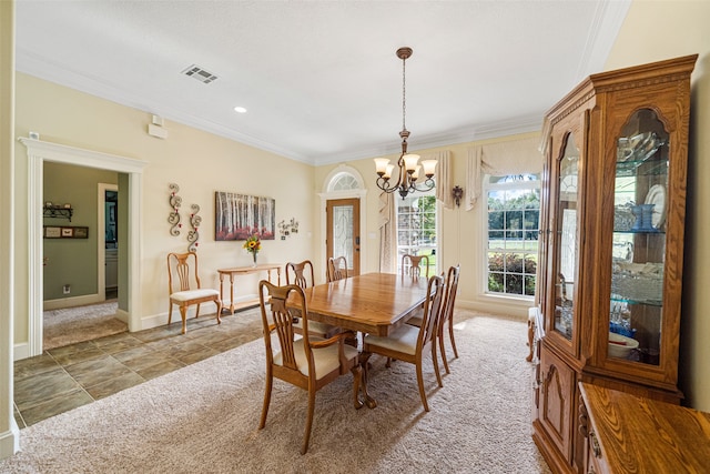 carpeted dining area featuring crown molding and a chandelier