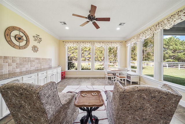 interior space featuring ceiling fan and ornamental molding