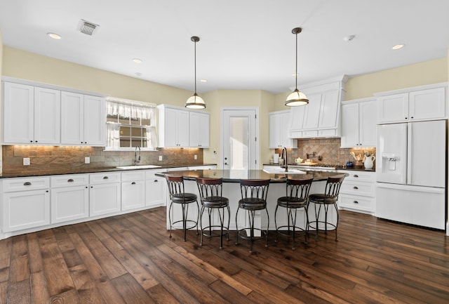 kitchen featuring white cabinetry, sink, white fridge with ice dispenser, and dark wood-type flooring