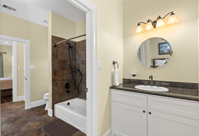 full bathroom featuring tiled shower / bath combo, toilet, and vanity