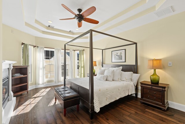 bedroom featuring a tray ceiling, ceiling fan, and dark hardwood / wood-style flooring