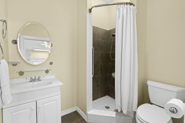 bathroom featuring a shower with shower curtain, vanity, tile patterned flooring, and toilet