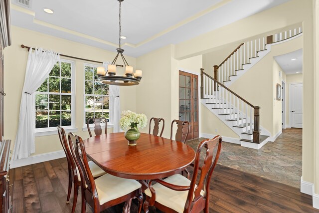 dining area featuring a chandelier, dark wood-type flooring, and a tray ceiling