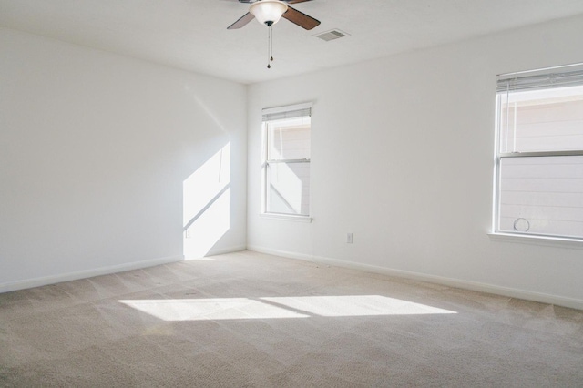 carpeted empty room featuring ceiling fan and a healthy amount of sunlight