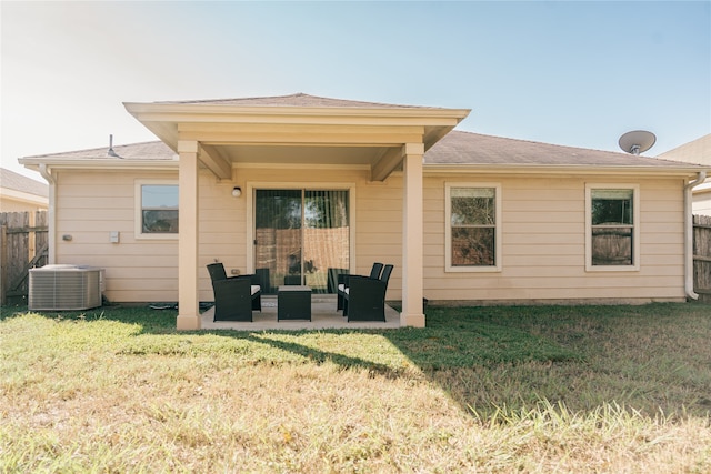 rear view of property featuring outdoor lounge area, a patio, central AC, and a lawn