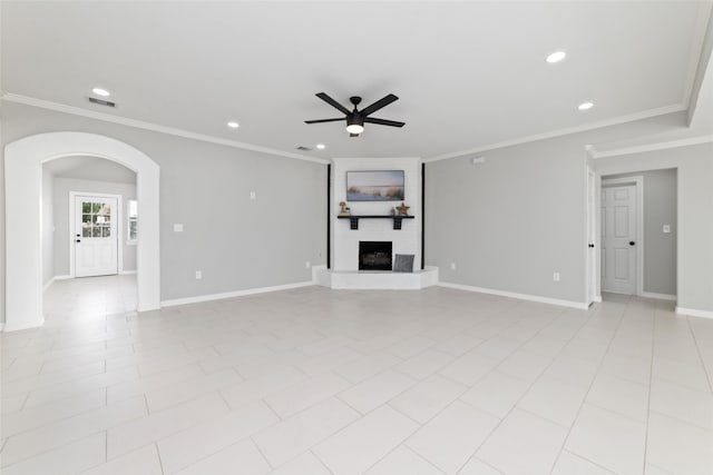 unfurnished living room featuring light tile patterned floors, a large fireplace, ceiling fan, and ornamental molding