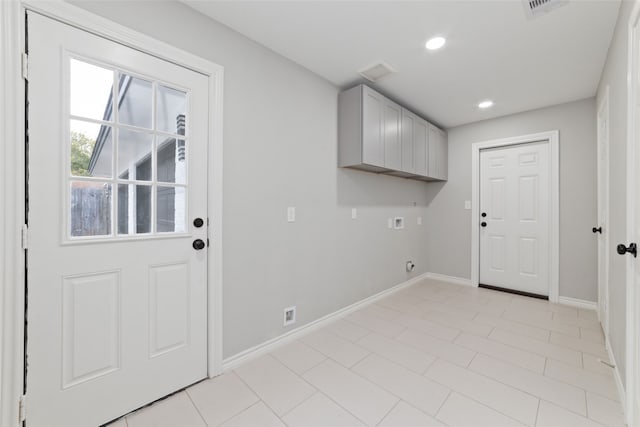 clothes washing area with cabinets, washer hookup, electric dryer hookup, and light tile patterned flooring