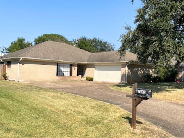 ranch-style home with a garage and a front lawn