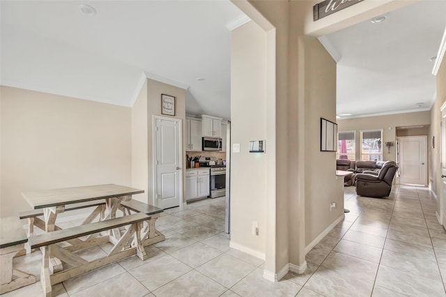 hallway featuring light tile patterned floors and ornamental molding