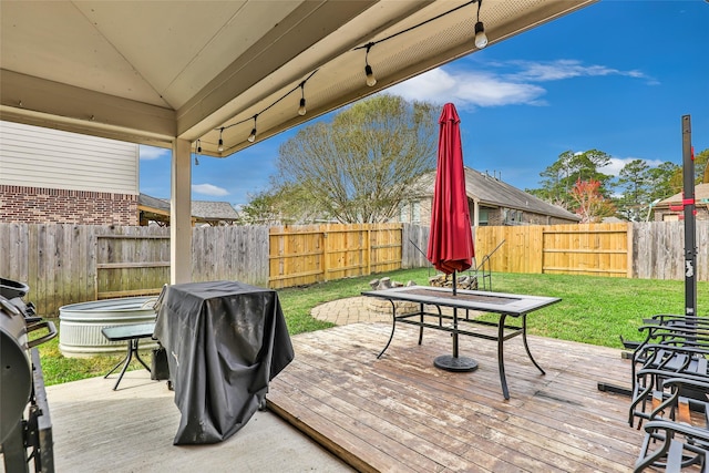 wooden terrace featuring a yard and area for grilling