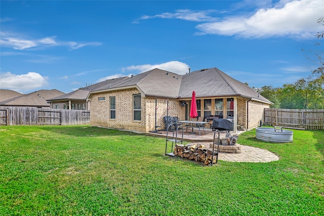 rear view of property with a lawn and a patio