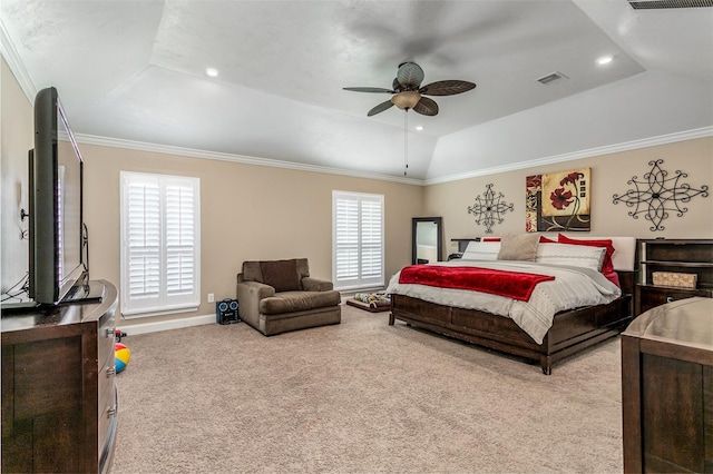 carpeted bedroom featuring a tray ceiling, multiple windows, ceiling fan, and crown molding