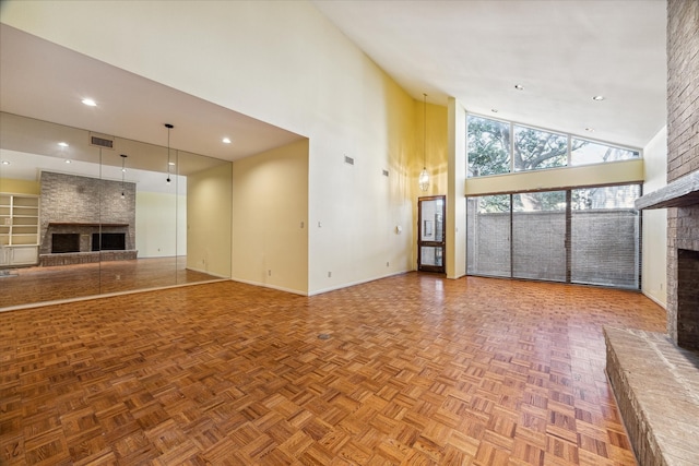 unfurnished living room featuring parquet flooring, a fireplace, and high vaulted ceiling