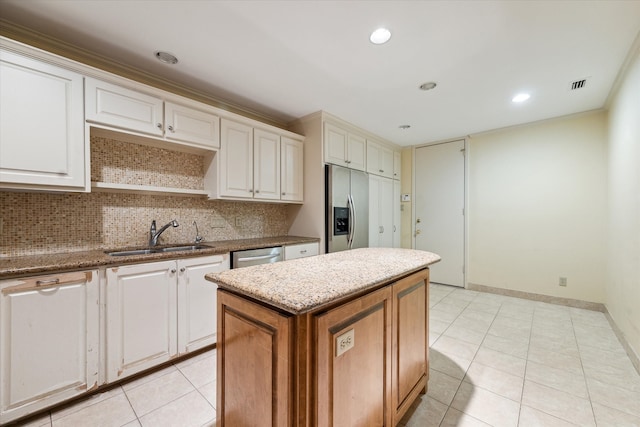 kitchen featuring a kitchen island, white cabinetry, sink, and appliances with stainless steel finishes