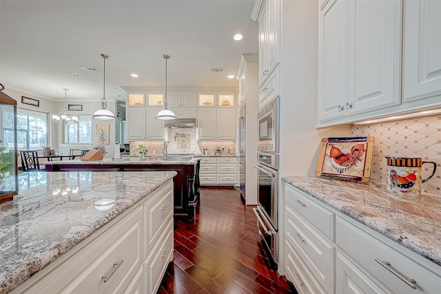 kitchen featuring backsplash, stainless steel oven, dark hardwood / wood-style flooring, and white cabinets