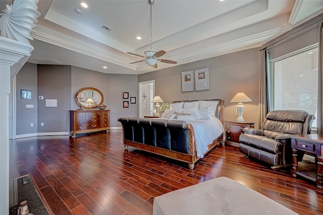 bedroom featuring ceiling fan, a raised ceiling, and dark wood-type flooring