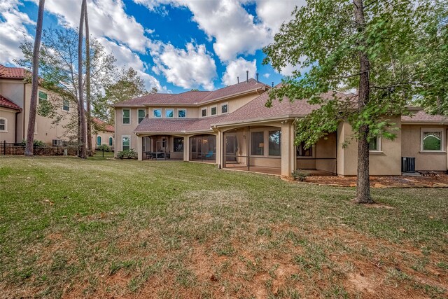 rear view of house with a sunroom and a yard