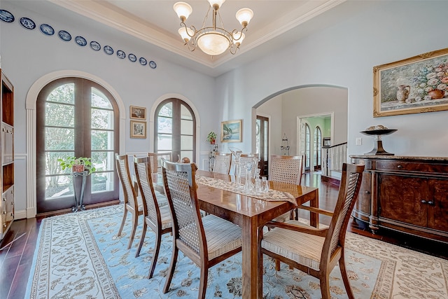 dining space with a chandelier, hardwood / wood-style floors, french doors, and ornamental molding