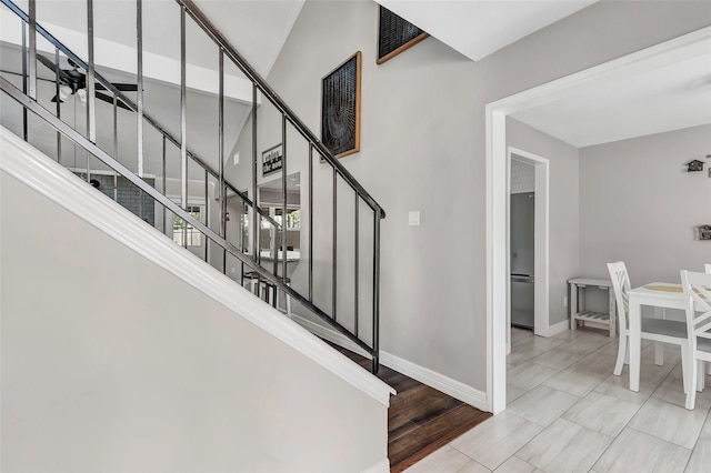 stairs featuring ceiling fan