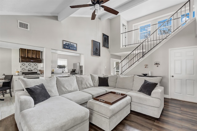 living room with ceiling fan, sink, beamed ceiling, and dark hardwood / wood-style floors