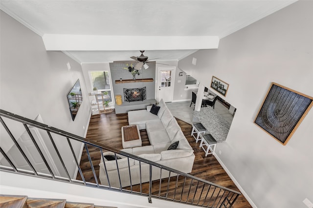 living room featuring hardwood / wood-style floors, a brick fireplace, ceiling fan, and crown molding