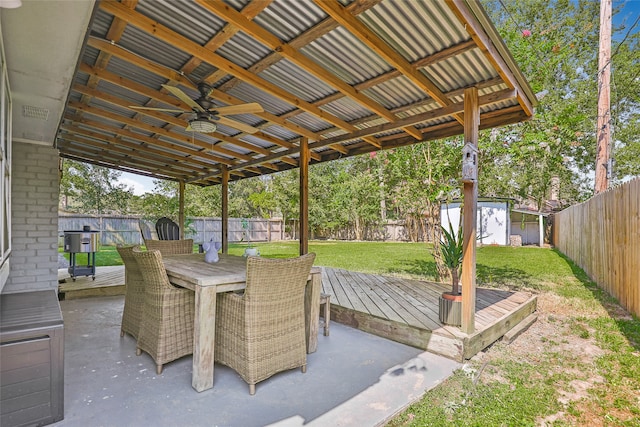 view of patio / terrace with ceiling fan, a storage unit, and a wooden deck