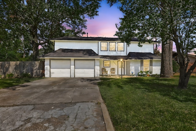 front of property featuring a garage and a lawn