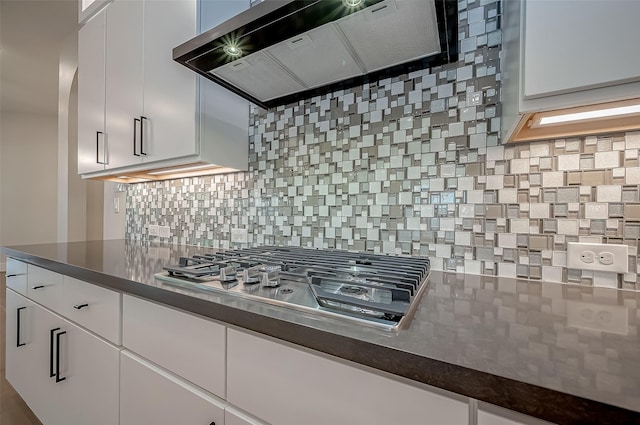 kitchen featuring stainless steel gas cooktop, white cabinetry, backsplash, and exhaust hood