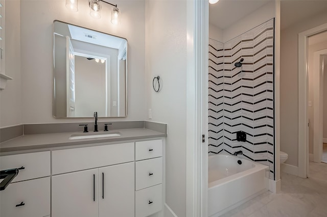 full bathroom with vanity, tiled shower / bath, and toilet