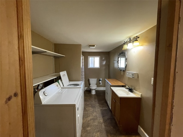 washroom with sink and washing machine and clothes dryer