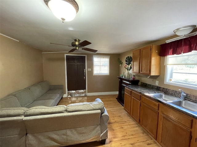 kitchen featuring ceiling fan, a healthy amount of sunlight, sink, and light hardwood / wood-style flooring