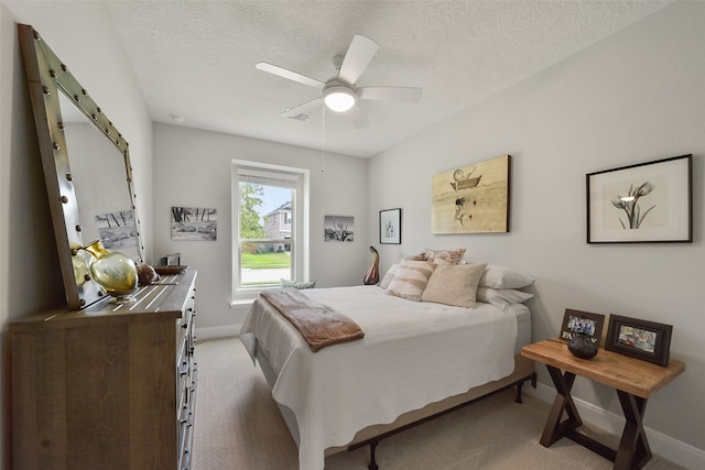 carpeted bedroom with ceiling fan and a textured ceiling