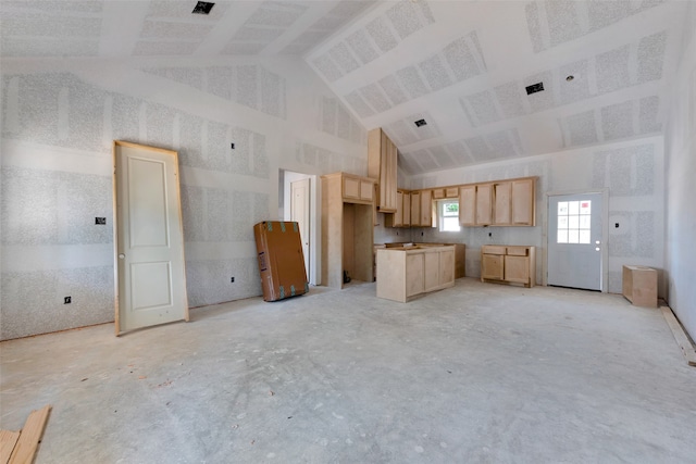 kitchen featuring light brown cabinets and high vaulted ceiling