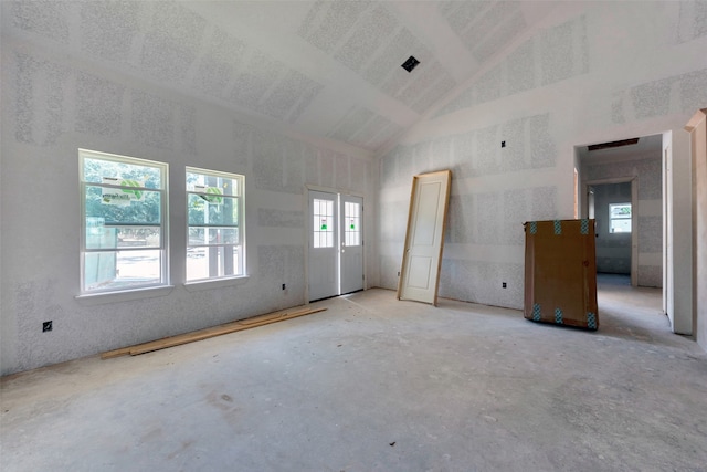 unfurnished room with high vaulted ceiling