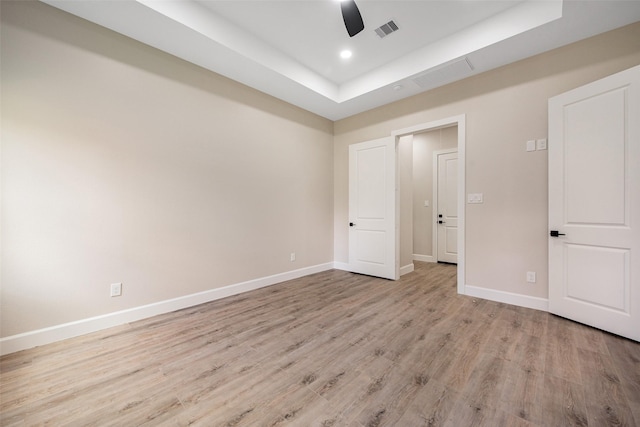 24601 Tipperary St, Hempstead, TX 77445 - unfurnished bedroom featuring visible vents, baseboards, light wood-type flooring, a tray ceiling, and a ceiling fan