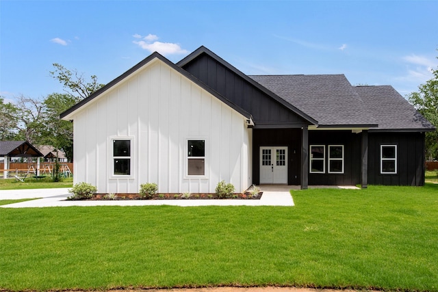 24601 Tipperary St, Hempstead, TX 77445 - back of house featuring board and batten siding, roof with shingles, and a yard
