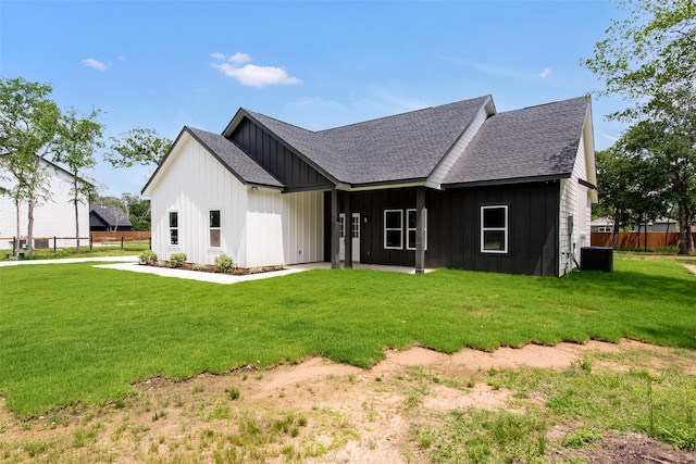 24601 Tipperary St, Hempstead, TX 77445 - rear view of house with roof with shingles, board and batten siding, a yard, and cooling unit