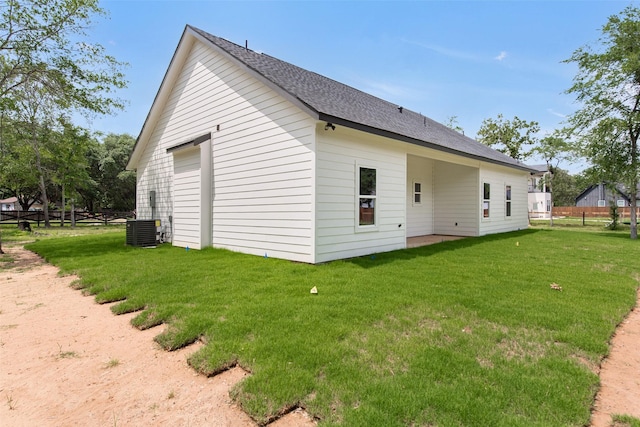 24601 Tipperary St, Hempstead, TX 77445 - back of property with a lawn, fence, central AC unit, and roof with shingles