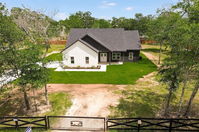 24601 Tipperary St, Hempstead, TX 77445 - rear view of property featuring a shingled roof, board and batten siding, fence, and a yard
