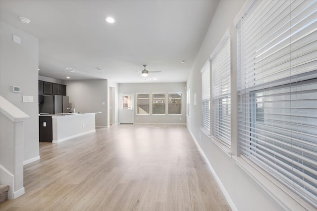 unfurnished living room featuring ceiling fan and light hardwood / wood-style flooring