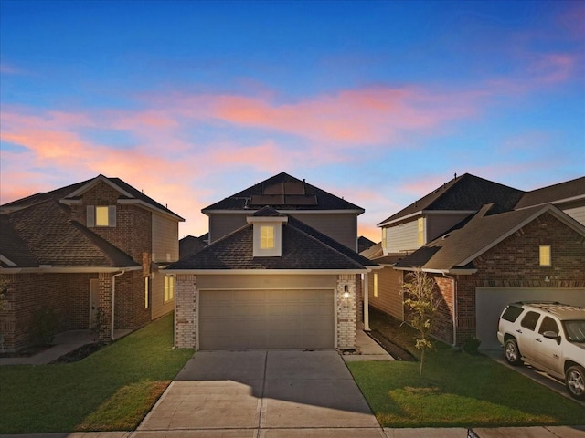 9210 Wood Beach Way, Houston, TX 77034 - traditional home featuring a garage, concrete driveway, a front lawn, solar panels, and brick siding