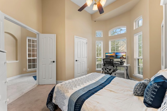 bedroom with light colored carpet, high vaulted ceiling, and ceiling fan