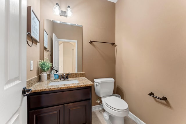 bathroom with tile patterned flooring, vanity, and toilet