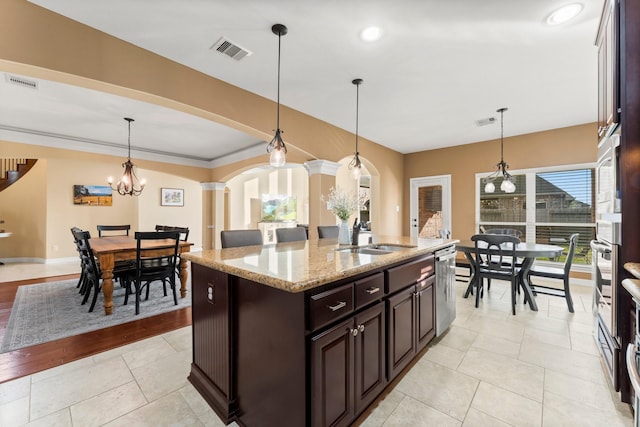 kitchen with a sink, visible vents, arched walkways, and stainless steel dishwasher