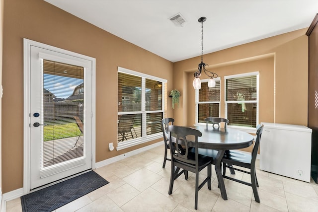 dining area featuring light tile patterned floors, baseboards, and visible vents